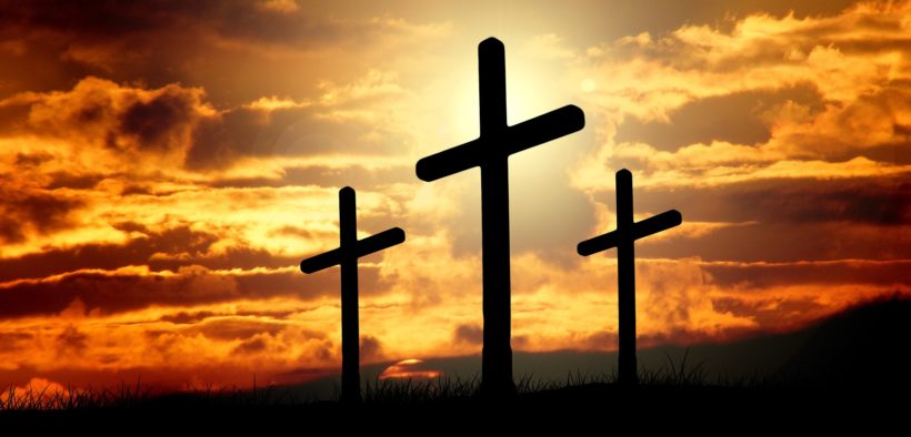 Three crosses silhouetted at sunset.