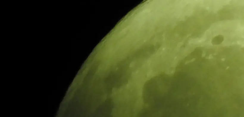 Close-up of moon with green hue.