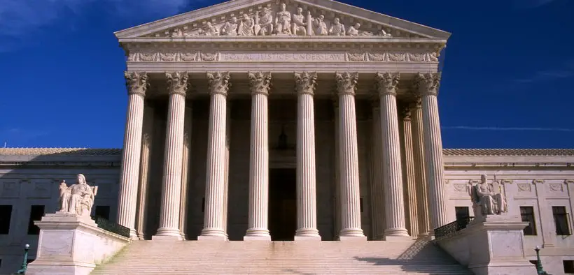 Supreme Court building from outside underneath a blue sky.