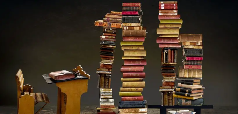 Writing desk and stacks of books.