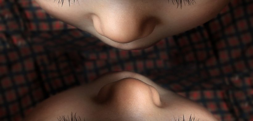 Child looking into mirror from above.