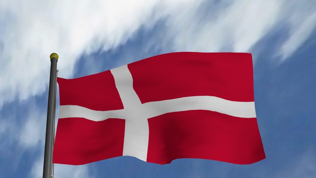 Denmark's flag flying against a partly cloudy sky.